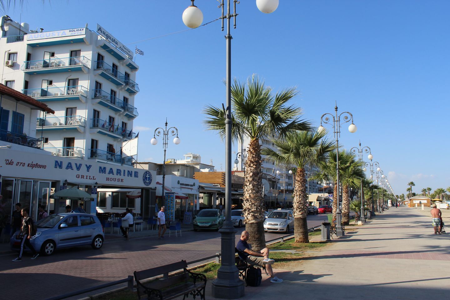 deptak z palmami i restauracjami przy promenadzie Finikoudes w Larnace