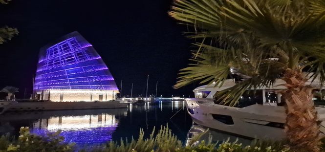 marina Ayia Napa nocą z podświetlonym budynkiem i jachtem