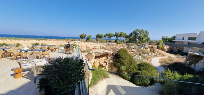 taras restauracji nad morzem z widokiem na skalne groty w Paralimni